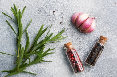 Gri arkaplanda yeşil biberiye ve sarımsaklı biber dalları..