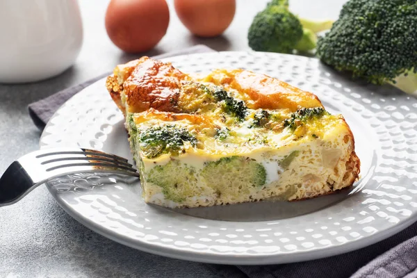 Piece Baked omelet with broccoli on a plate. Concrete table. Healthy diet food dish. — Stock Photo, Image