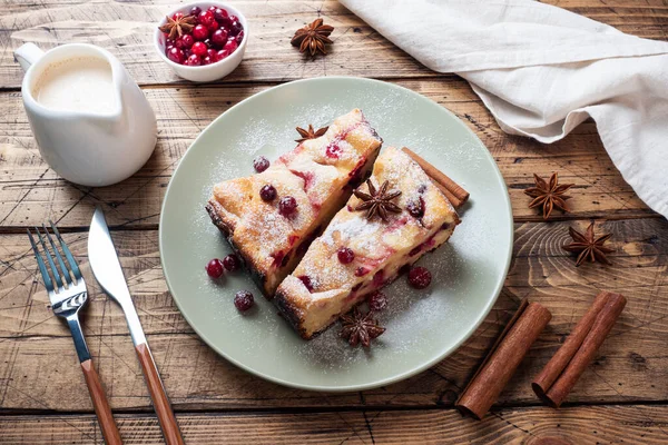 Dos trozos de pastel de requesón cazuela con bayas de arándano y especias de canela y anís en un plato. Fondo de madera. — Foto de Stock