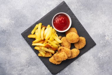 Kızarmış patates ve ketçap soslu tavuk nugget. Fast food sağlıksız yiyecek kavramı. Gri beton tablo Boşluğu kopyala.