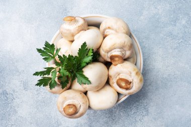 Maydanozlu tabak içinde çiğ mantar şampiyonları. Boşluğu kopyala.
