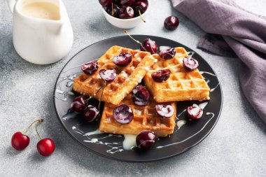 Taze kiraz ve kremalı Belçika flüt waffle 'ı. Yumuşak ev yapımı waffle, kirazlı tatlı.