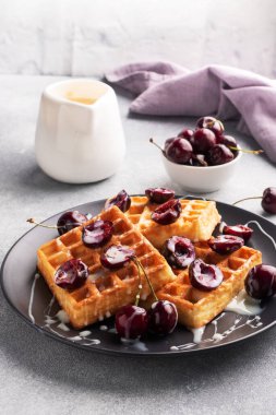 Taze kiraz ve kremalı Belçika flüt waffle 'ı. Yumuşak ev yapımı waffle, kirazlı tatlı.