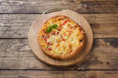 Ahşap arka planda domates ve peynirli ev yapımı pizza. Boşluğu kopyala