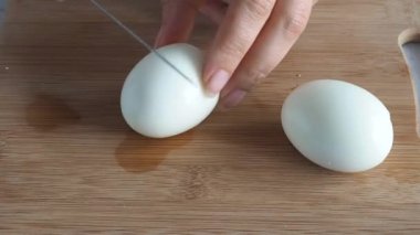 Kızlar bir bıçakla haşlanmış tavuk yumurtasını kestiler. Evde Kahvaltı Hazırlanıyor.