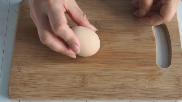 女性の手を閉じるをきれいにゆでた鶏の卵。ホームキッチン木製テーブル. — ストック動画