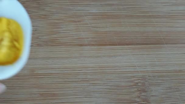 A főtt tyúktojás felét fából készült vágódeszkára helyezik. Közelről.. — Stock videók