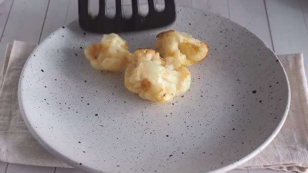 El chef pone las flores de coliflor frita en un plato. — Vídeos de Stock