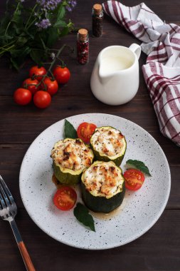 Fırında doldurulmuş kabak sütunları, kıymalı tavuk ve sebzeler. Koyu ahşap arka plan. Boşluğu kopyala