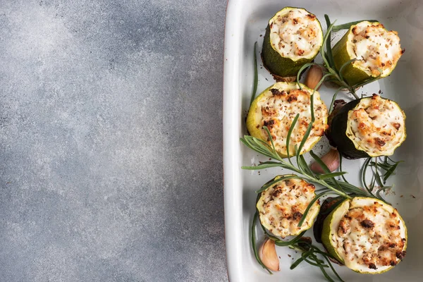 Bakade fyllda zucchini kolumner med malet kyckling och grönsaker i en keramisk bakning skålen. kopieringsutrymme — Stockfoto