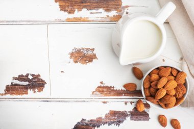 Gri arka planda seramik süt sürahisinde badem sütü. Boşluğu kopyala