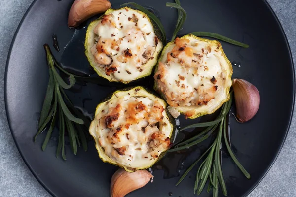 Bakade fyllda zucchini kolumner med malet kyckling och grönsaker på en tallrik. Grå betong bakgrund. — Stockfoto