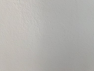 Boyalı duvarın yumuşak dokusu, bir tarafı aydınlık. Beyaz yüzeyin soyut arka planı. Parça