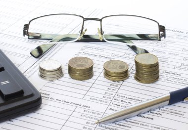 Finansal ve muhasebe raporları, madeni paralar, gözlükler ve hesap makinesi. Vergi planlama ve bütçe yönetimi kavramları.