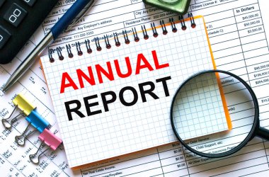 Not defterine hesap makinesi, klipler ve finansal raporla ilgili yıllık metin raporu. İş ve mali konzept