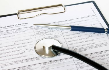 Masada steteskop ve gümüş kalemle duran reçete formu. İlaç ya da eczane kavramı.