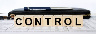 Tahta bir küpte kalem ve cüzdanla yazılmış bir kelime kontrolü. İş ve mali konzept