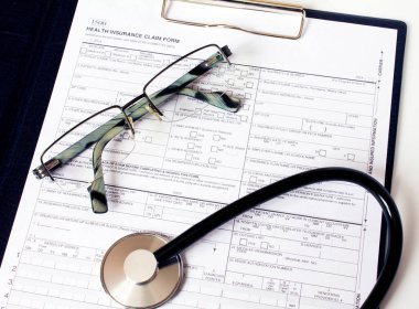 Masada steteskop ve gümüş gözlüklerle duran reçete formu. İlaç ya da eczane kavramı.