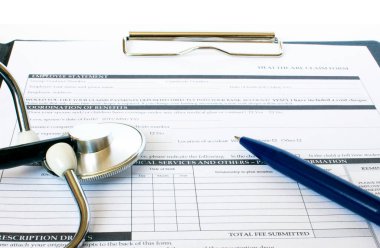 Masada steteskop ve mavi kalemle duran reçete formu. İlaç ya da eczane kavramı.