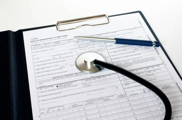 Masada steteskop ve gümüş kalemle duran reçete formu. İlaç ya da eczane kavramı.