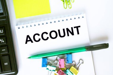 Metin Hesablı Not Defteri. Hesap makinesi, yeşil kalem etiketleri ve kırtasiye klipsleri. İş ve mali konsept