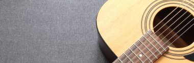 Gri ahşap arka planda mavi bir akustik gitarın parçası.
