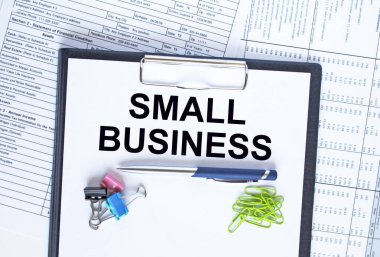 Klasördeki Küçük İşletme 'ye şarjör ile mesaj at. Finans masasında ataç olan kalem. İş ve mali konsept