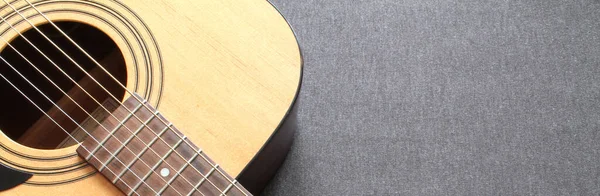 Gri arka planda akustik gitarın bir parçası
