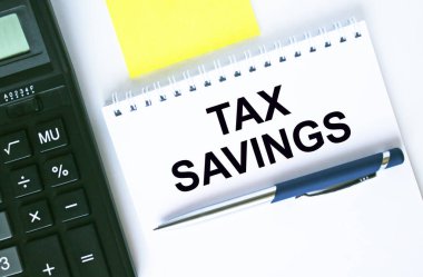 Metin Vergi Tasarrufları ile not defteri. Hesap makinesi, kalem ve çıkartmalar. İş ve mali konsept