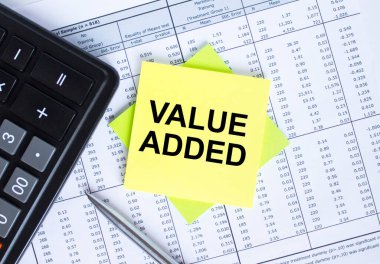 Finansal tablolara eklenmiş metin değeri etiketi. Metal kalemle hesap makinesi. İş ve mali konsept