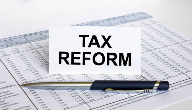 Finansal tablosunda mavi metal kalem olan beyaz karta Vergi Reformu yaz. İş ve mali konsept