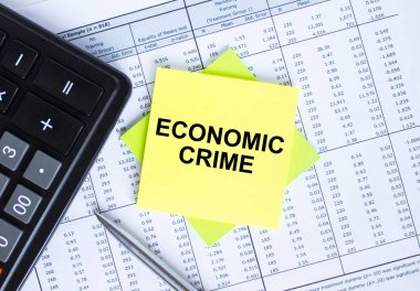 Finansal tabloların üzerinde yazılı Ekonomik Suçlar etiketi var. Metal kalemle hesap makinesi. İş ve mali konsept