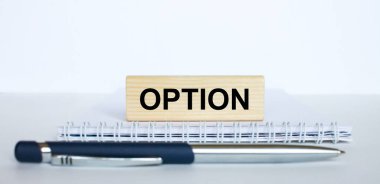 Metal mavi bir kalemle bir not defterinin üzerinde duran jenga ağacının üzerindeki opsiyon kelimesi. İş konsepti fotoğrafı