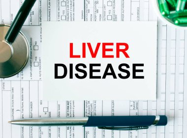 Steteskop, kalem, yeşil haplar ve tıbbi belgeler olan beyaz karttaki karaciğer hastalığına mesaj at. Tıbbi konsept fotoğrafı