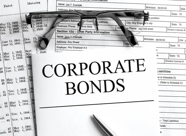 Paper with text Corporate Bonds on a financial table with eyeglasses and metal pen. Financial and concept photo