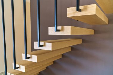 Yüzen merdivenler. Kahverengi duvara bağlı korkuluk ile Kül kereste merdivenler ve şık modern evin içinde ikinci kata giden