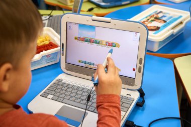 Stylus kalemi dizüstü bilgisayarda çalışan bir küçük çocuk