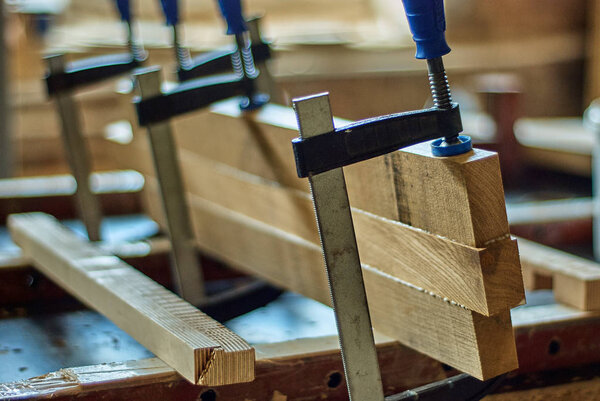 Gluing the board with clamps in a joinery workshop