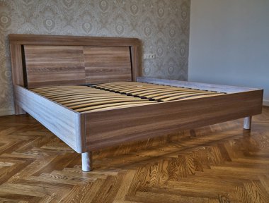 Yatak sağlam meşe yapılmış. Yatağın üzerine desenli duvar kağıdı ve ahşap döşeme arka planı