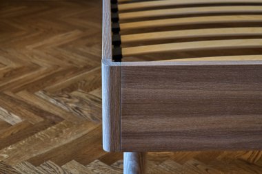 Yatak sağlam meşe yapılmış. Yatağın üzerine desenli duvar kağıdı ve ahşap döşeme arka planı