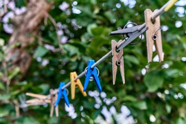 Bir ip üzerinde asılı clothespin. Plastik ve ahşap clothespins farklı renklerde