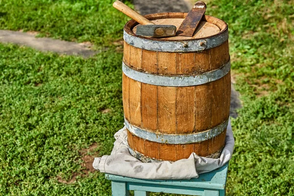 Wooden barrel for 20 liters. Wooden barrel covered with wax on the background of green grass