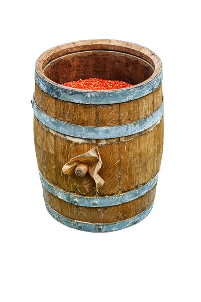 Open wooden barrel filled with milled hot pepper. Hot sauce production. Wooden barrel covered with wax. Isolated on white background