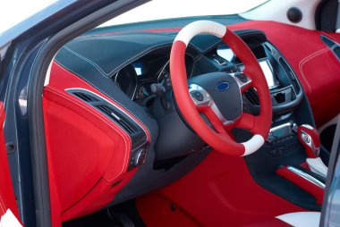 Car interior details. Car dashboard. Steering wheel. Red and black alcantara with stitching. Close-up clipart