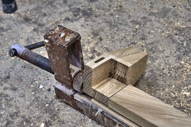 Mobilya legs--dan sağlam meşe. Yakın çekim. Metal ahşap detayları sıkma kıskaç. Ahşap mobilya üretim süreci