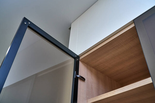 Wardrobe with glass framed doors. Frosted glass in aluminum frame. Wooden wardrobe close-up