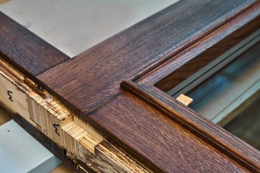 Ahşap kapı üretim süreci. Camlı kapı çerçeve, koyu renkte boyanmış. Ağaç işleme ve marangozluk üretim. Mobilya üretimi. Yakın çekim