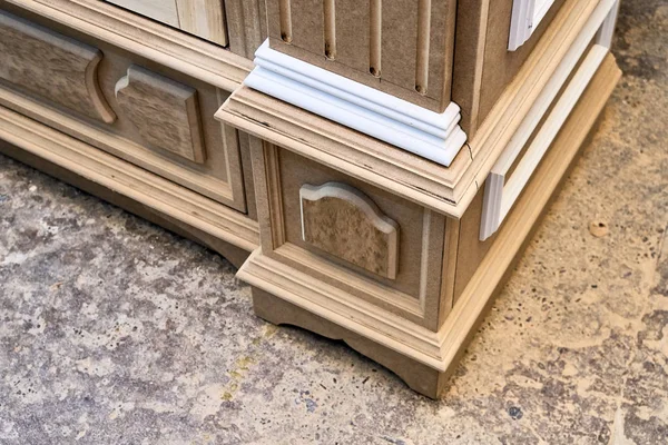 Mdf cabinet carcass with moldings and wooden carved capital. Wooden furniture manufacturing process — Stock Photo, Image