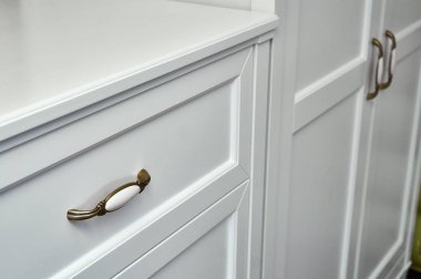 Çocuk dolabı ve çekmece sandığı. Beyaz renkli klasik çocuk mobilyaları yakın çekim