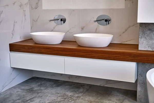 Luxury bathroom vanity. Stylish interior of modern bathroom with teak tabletop and marble walls